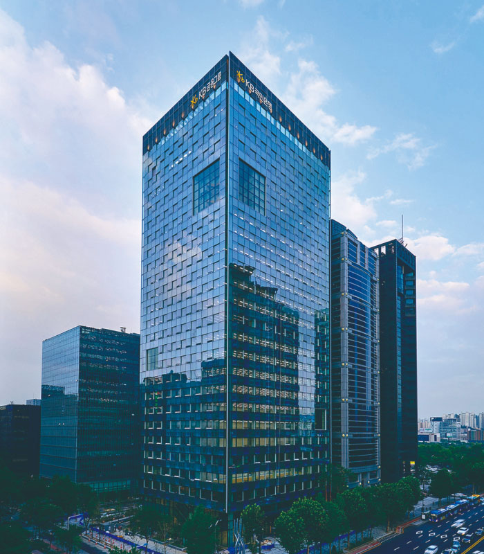 A picture of KB Financial Group building looking up from below so that you can see the sky